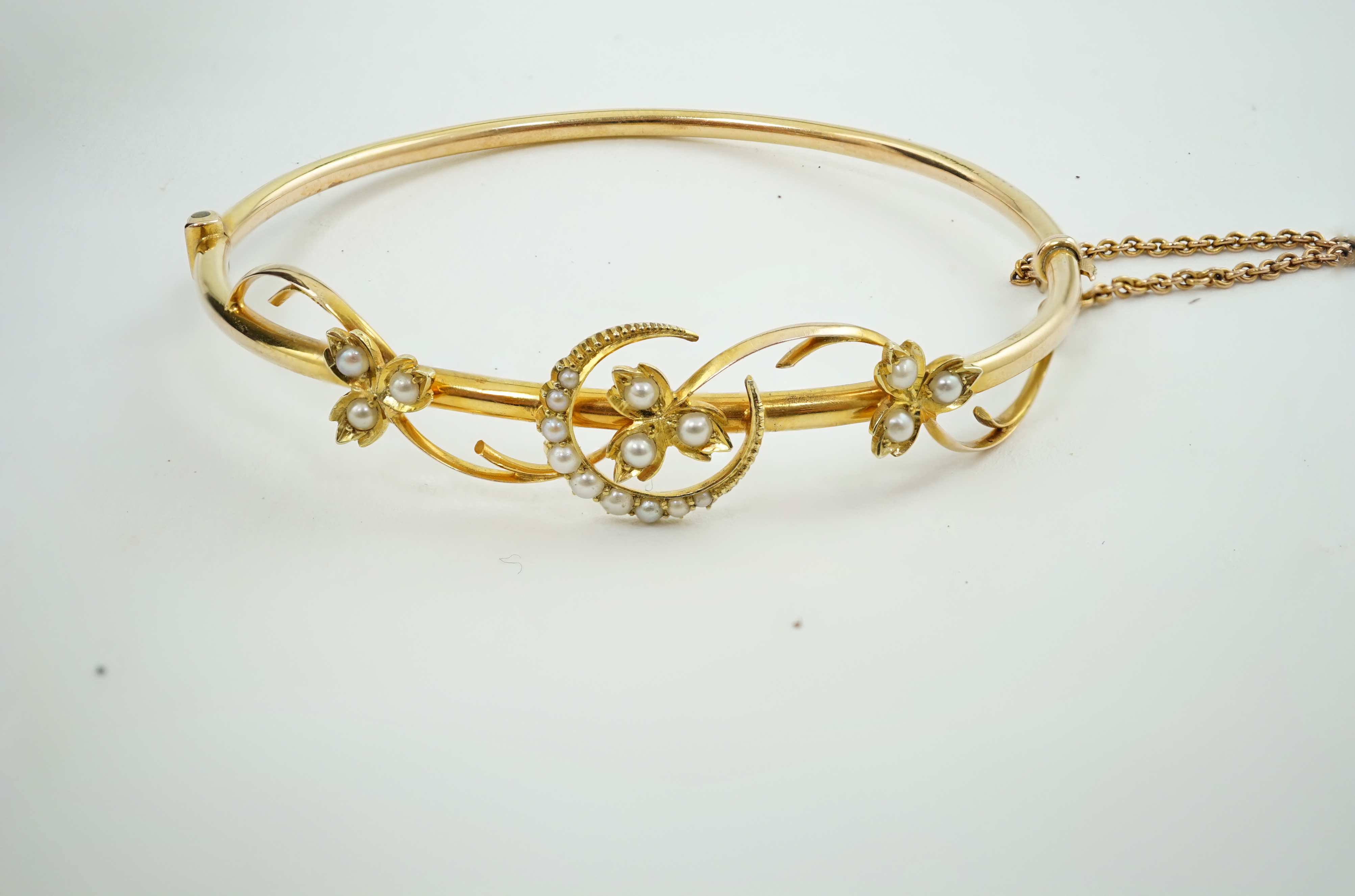 A Victorian 15ct gold and seed pearl set hinged bangle